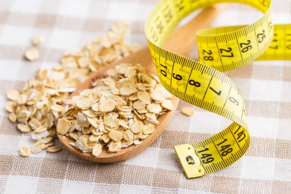 Diet concept. Oatmeal and measuring tape. — Stock Photo, Image