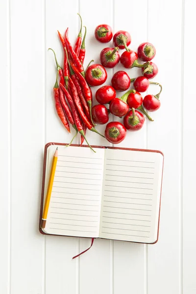 Lege receptenboek en hete chili pepers. — Stockfoto