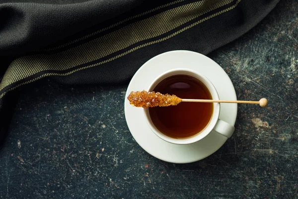 Hnědý jantar cukr krystal na dřevěnou hůl a tea cup. — Stock fotografie