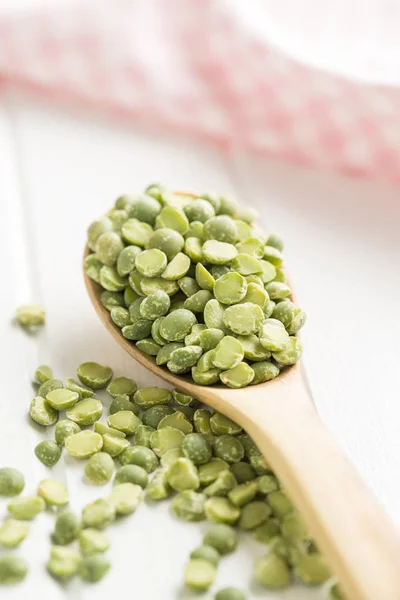 Pois cassés verts dans une cuillère en bois . — Photo