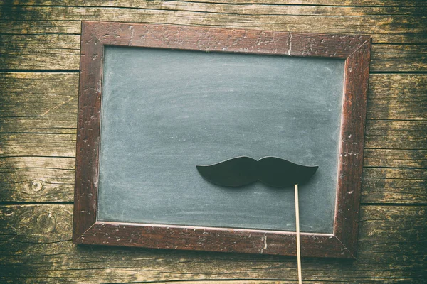 Blank chalkboard and fake mustache. — Stock Photo, Image