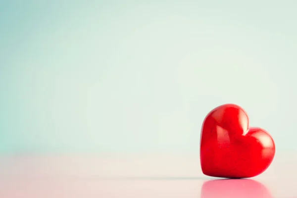 Красное сердце на розовом столе . — стоковое фото