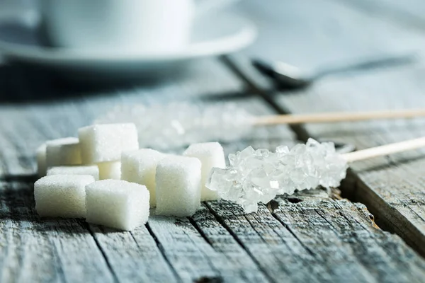 Crystallized sugar on wooden stick and sugar cubes. — Stock Photo, Image