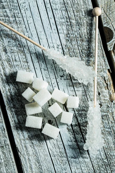 Crystallized sugar on wooden stick and sugar cubes. — Stock Photo, Image