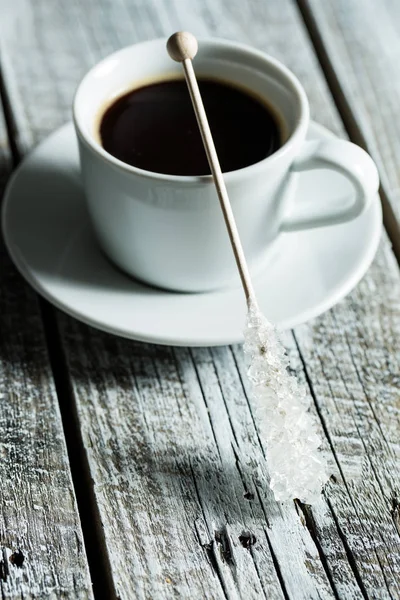 Crystallized sugar on wooden stick and coffee cup. — Stock Photo, Image