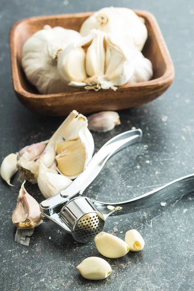 Garlic and garlic press. — Stock Photo, Image