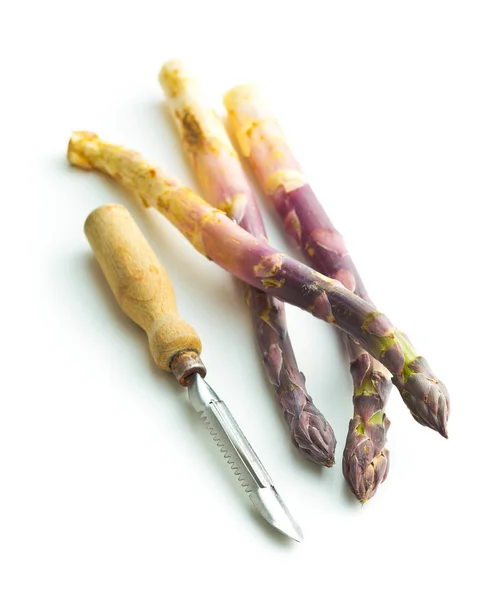 Asparagi viola freschi con pelapatate . — Foto Stock