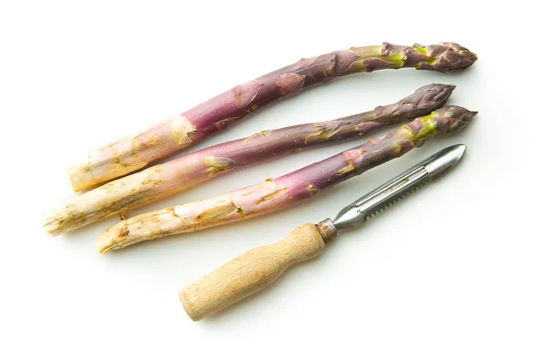 Asparagi viola freschi con pelapatate . — Foto Stock