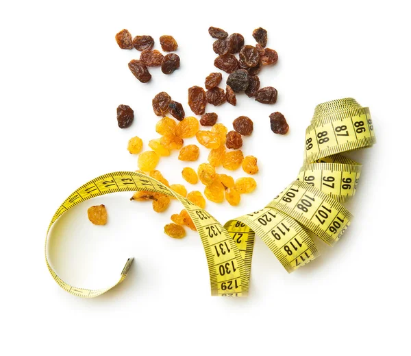 Sweet dried raisins and measuring tape. — Stock Photo, Image