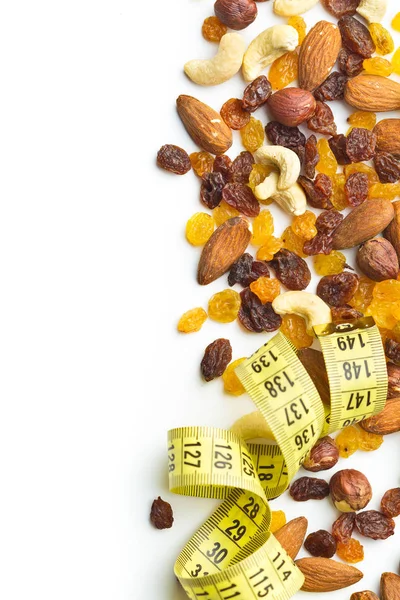 Various nuts and raisins with measuring tape. — Stock Photo, Image