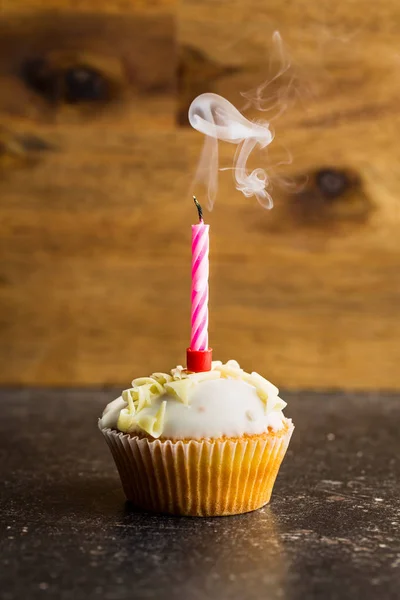 Cupcake com uma vela soprada . — Fotografia de Stock