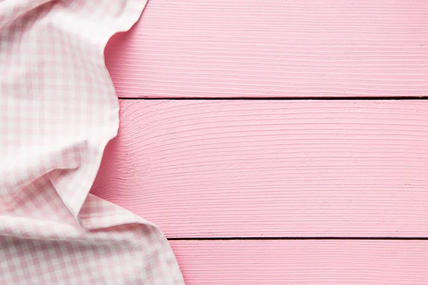Geruit tafelkleed over roze houten tafel. — Stockfoto