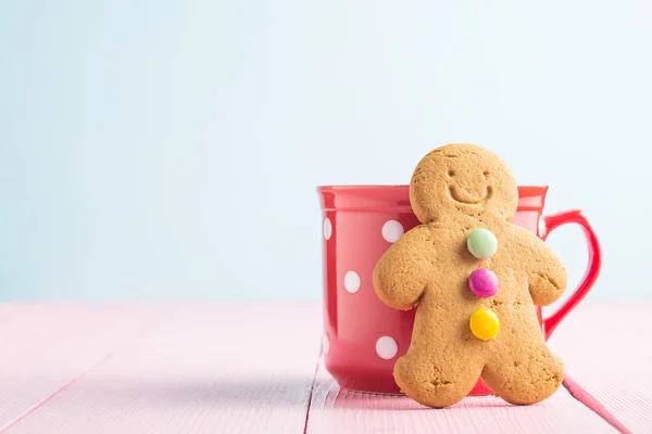 Pepparkaksgubben lutad mot en kopp. — Stockfoto