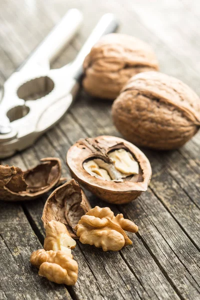 Cracked dried walnuts and nutcracker. — Stock Photo, Image