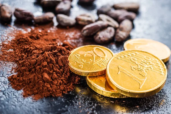 Donkere cacaopoeder, cacaobonen en chocolade munten. — Stockfoto