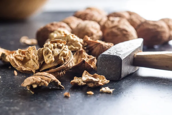 Tasty dried walnuts and hammer. — Stock Photo, Image