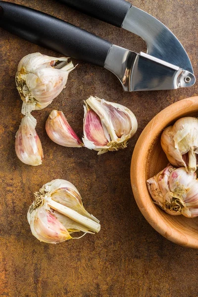 Fresh garlic and garlic presser. — Stock Photo, Image