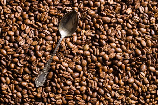 Roasted coffee beans and silver spoon. — Stock Photo, Image
