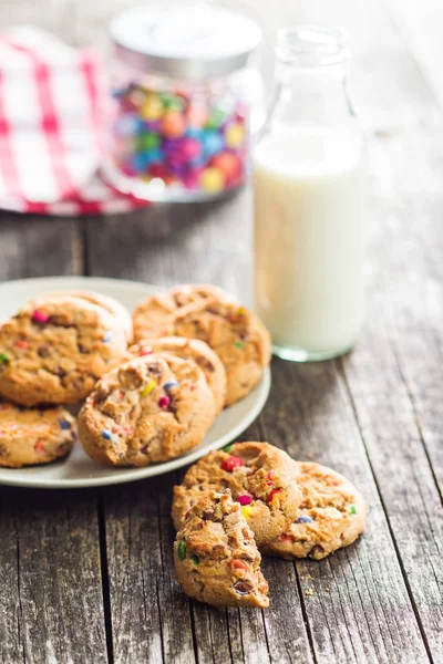 Süße Kekse mit bunten Bonbons und Milch. — Stockfoto