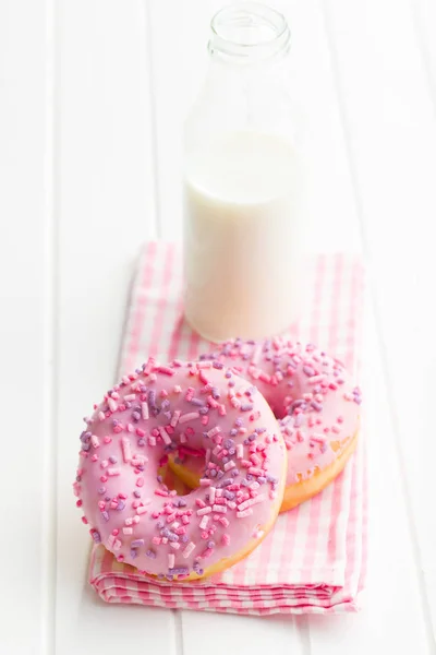 Розовые пончики и молочная бутылка . — стоковое фото