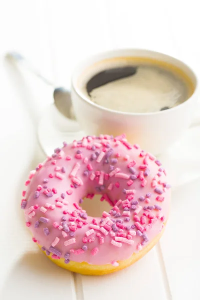 Розовый пончик и чашка кофе . — стоковое фото