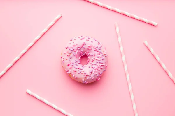 Rosa donut och rosa sugrör. — Stockfoto