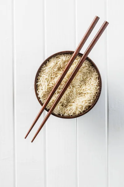 Arroz longo indiano não cozido em tigela e pauzinhos . — Fotografia de Stock