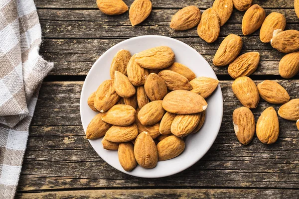 Nueces Almendras Secas Plato Sobre Mesa Madera Vieja Vista Superior — Foto de Stock