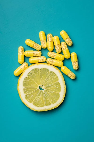 Cápsulas Vitaminas Píldoras Vitamina Rodaja Limón Sobre Fondo Colorido Vista —  Fotos de Stock
