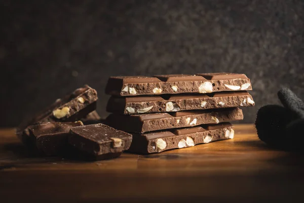 ミルクチョコレートバー 木のテーブルの上の茶色のナッツチョコレート — ストック写真