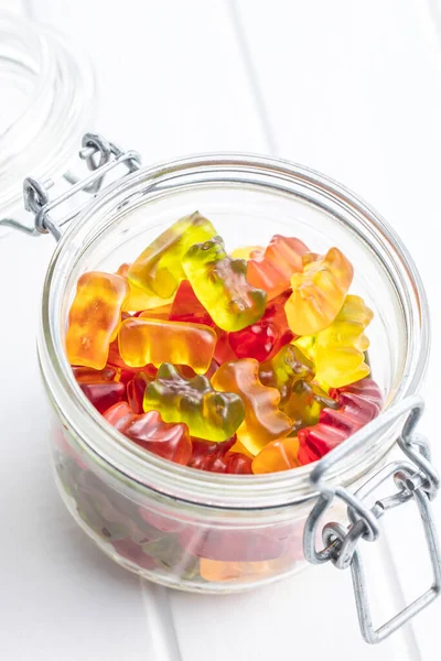 软糖熊 果冻糖 在白桌子上的罐子里放着色彩艳丽的领带 — 图库照片