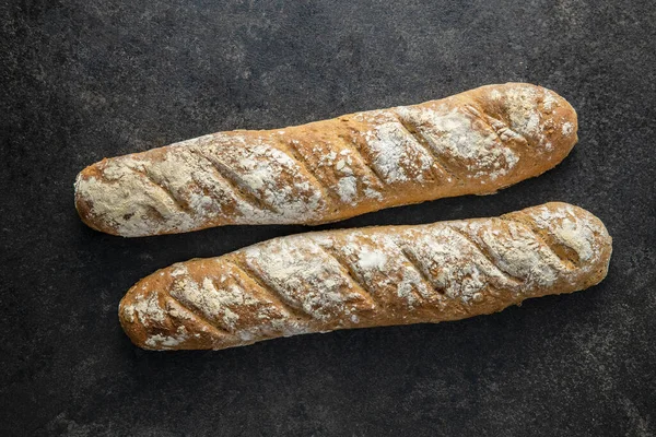 Two Fresh Whole Grain Bread Baguettes Black Table Top View — Stock Photo, Image