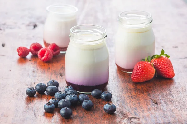 Iogurte Frutado Branco Jarra Mirtilos Framboesas Morangos Mesa Madeira — Fotografia de Stock