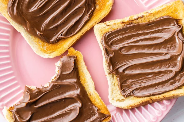 Roti Panggang Dengan Hazelnut Menyebar Piring Merah Muda Krim Cokelat — Stok Foto