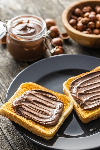 烤面包 用榛子铺在盘子上 甜巧克力奶油 — 图库照片