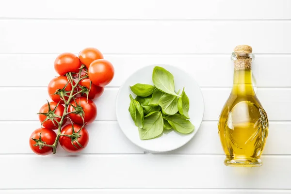 Kirschtomaten Basilikumblätter Und Olivenöl Flasche Auf Weißem Tisch Ansicht Von — Stockfoto