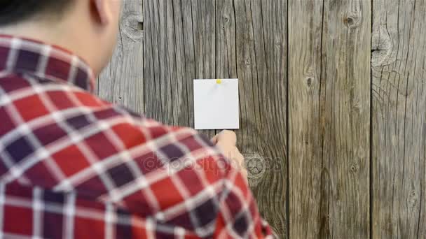 Homem atribui adesivos multicoloridos — Vídeo de Stock