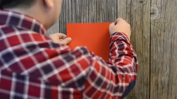 Homem anexa folha de papel vermelho — Vídeo de Stock