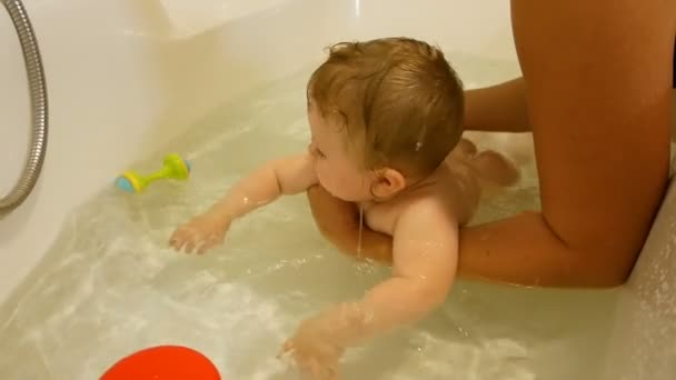 Pasgeboren baby spelen en glimlachend in het bad — Stockvideo