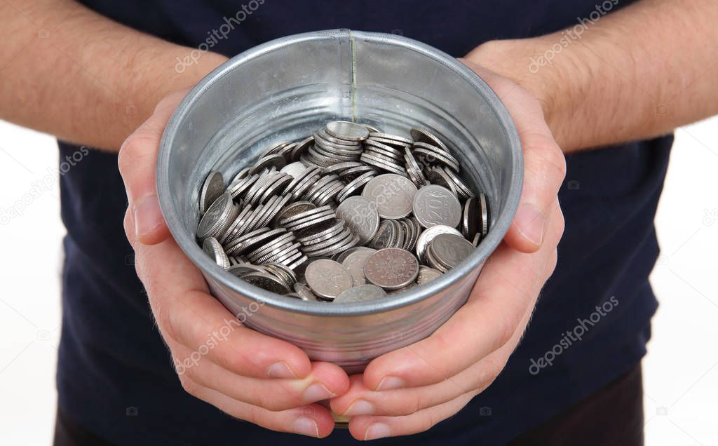 Old zinc bucket with silver coins in hands