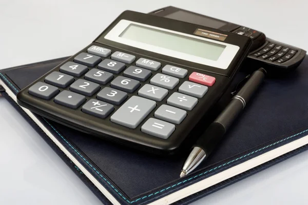 Planificador con pluma y calculadora sobre la mesa — Foto de Stock
