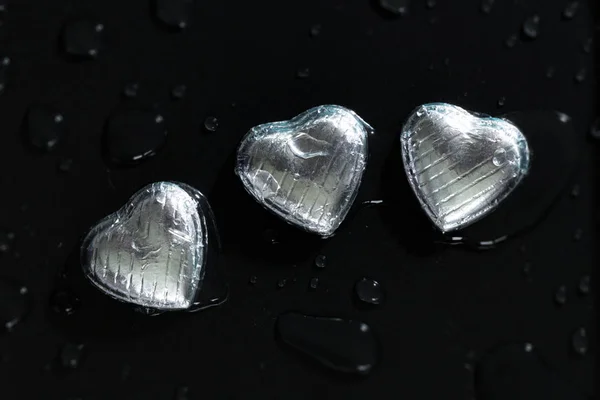 Three romantic chocolate hearts with water drops — Stock Photo, Image