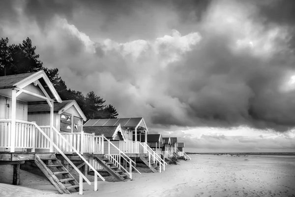 Beach hyddor i svartvitt på sandiga kusten Royaltyfria Stockfoton