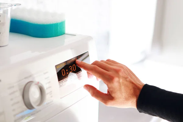 Homem escolher programa para máquina de lavar roupa — Fotografia de Stock