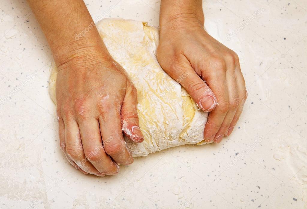 cook kneads dough for bread