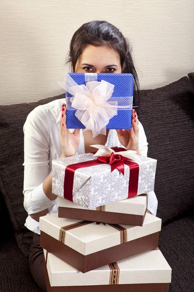 Mädchen hält eine der vielen Geschenkboxen in der Hand — Stockfoto