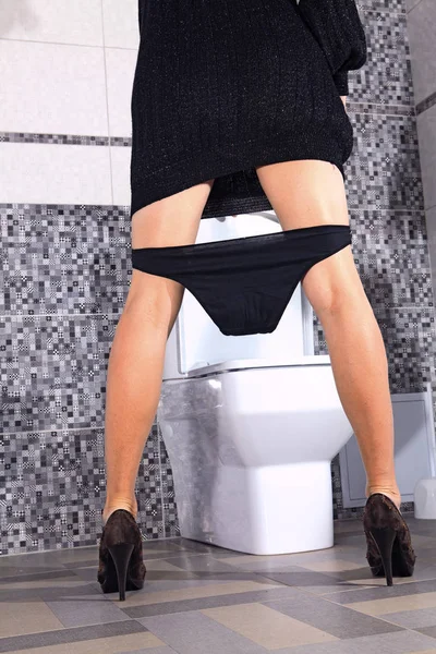 Rug van vrouw die verblijft in de buurt toilet kom — Stockfoto