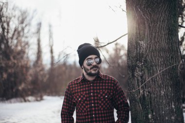 Siyah bir şapka ve güneş gözlüğü parkta giyen güzel esmer adam ekose gömlekli sakallı