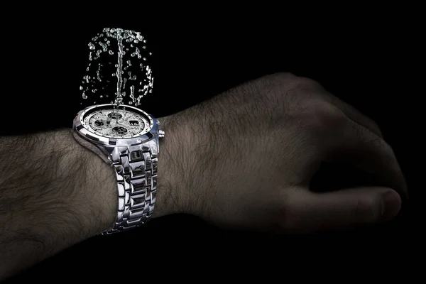 Stříbrné hodinky s fontánou na zápěstí člověka — Stock fotografie
