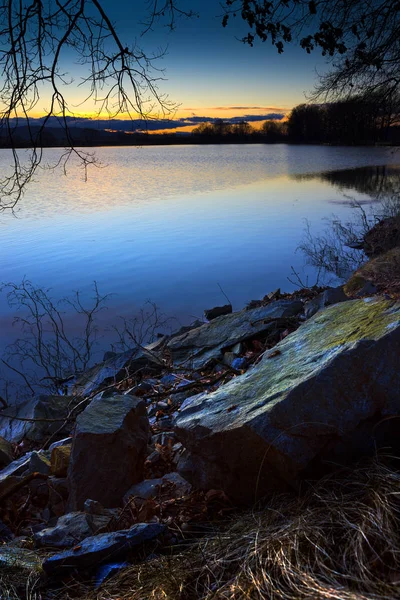 Big stone on the bank of deep blue lake. — Stock Photo, Image